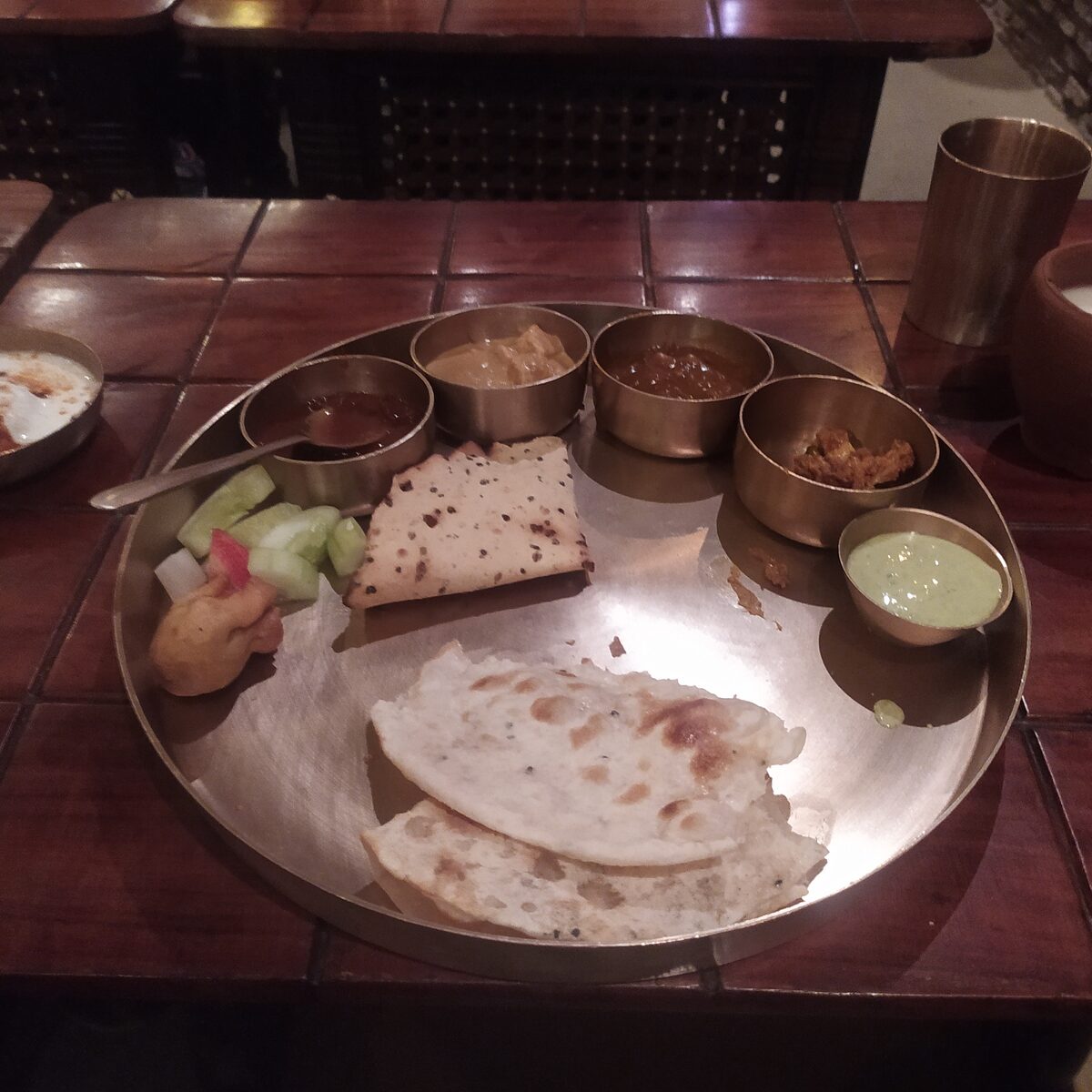 Punjabi thali spread with dips, roti and lassi